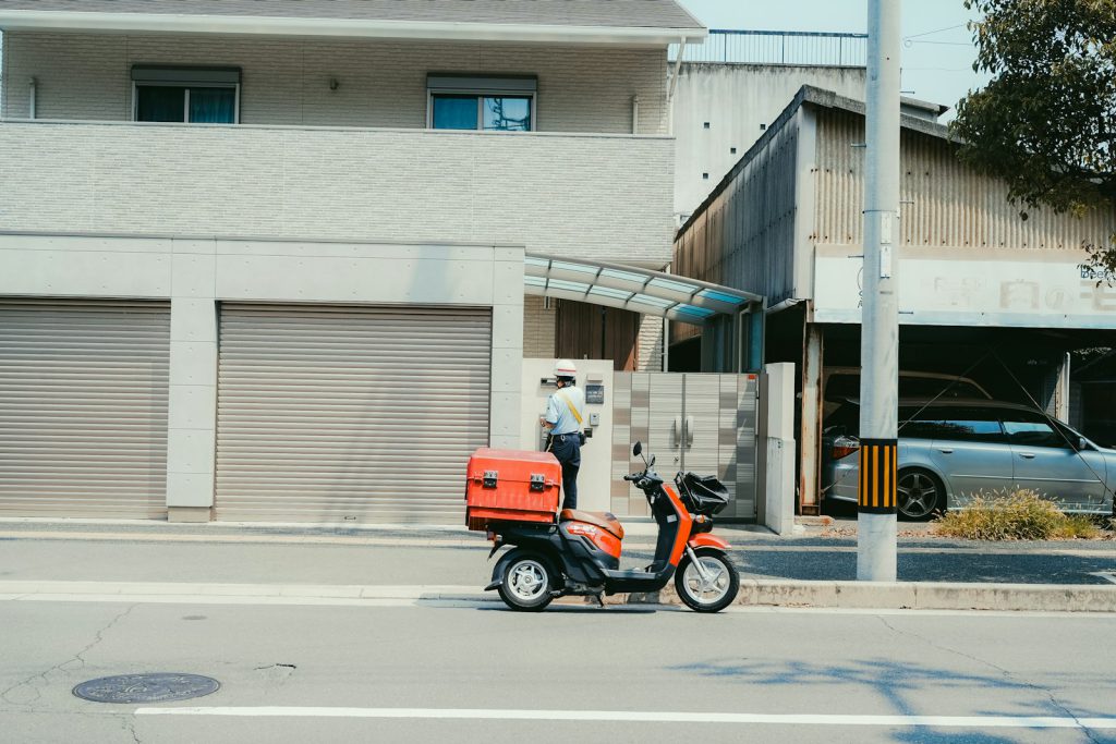 Delivery person on scooter arrives at house